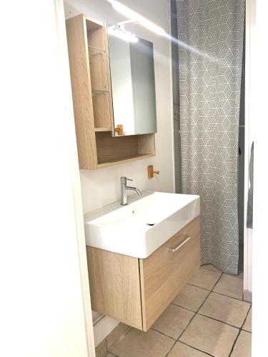 y baño con lavabo blanco y ducha. en locationbonappart1 en Limoges