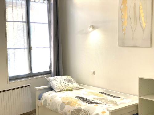 Habitación pequeña con cama y ventana en locationbonappart1 en Limoges