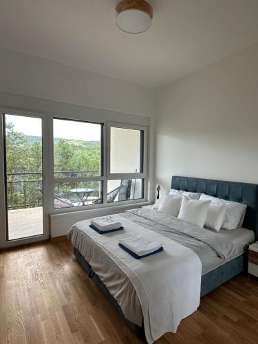 a bedroom with a large bed with two towels on it at Apartman 103 in Vrdnik