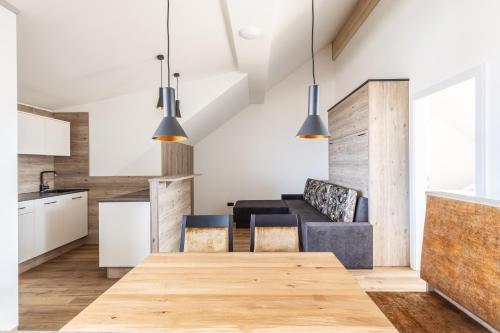 a kitchen and dining room with a wooden table and chairs at Alpen Krone by Maier - Dornbirn in Dornbirn