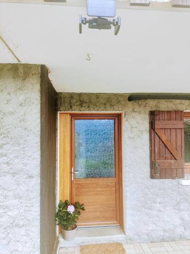 une porte dans un bâtiment blanc avec une plante en pot dans l'établissement Rez de jardin, vue panoramique, plein Sud, à Puy-Sanières
