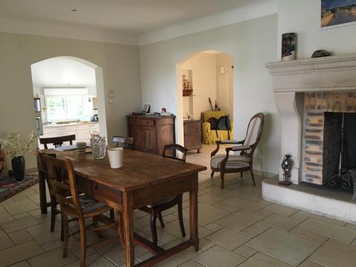 un salon avec une table et une cheminée dans l'établissement villa spacieuse avec piscine sur cote basque Anglet, à Anglet