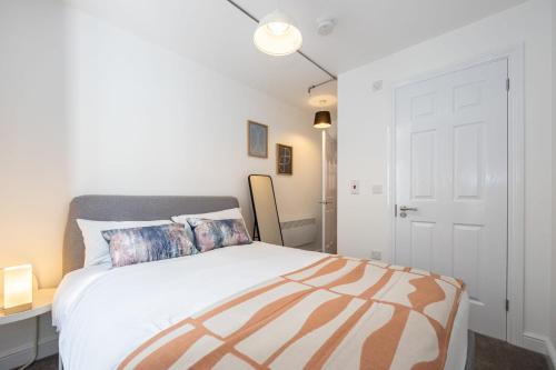 a white bedroom with a bed and a white door at Apartment For Two Near Bolton Train Station in Bolton