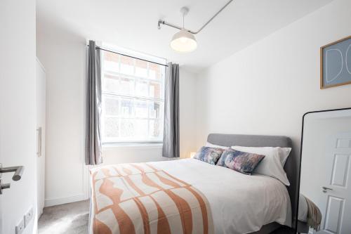 a white bedroom with a bed and a window at Apartment For Two Near Bolton Train Station in Bolton