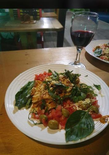 a plate of food on a table with a glass of wine at Casa heysol in Bahía de Caráquez
