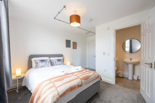 a white bedroom with a bed and a sink at Apartment For Two Near Bolton Train Station in Bolton