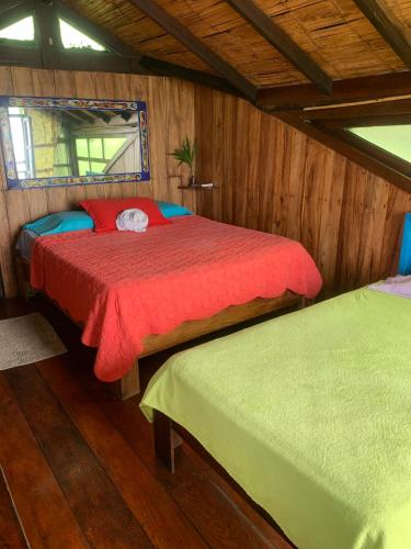 1 dormitorio con 2 camas en una habitación de madera en Casa heysol en Bahía de Caráquez