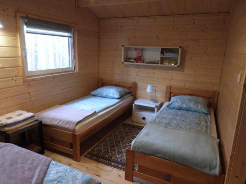 a room with two beds in a wooden cabin at Pokoje gościnne Ustronie in Zwierzyniec