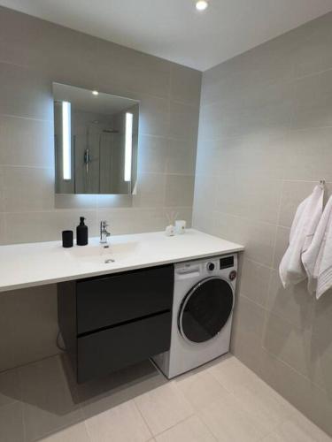 a bathroom with a sink and a washing machine at Moderne 3 Roms leilighet i Oslobukta! in Oslo