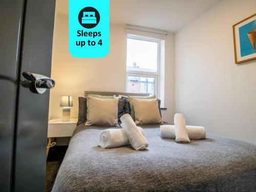 una camera da letto con un letto con cuscini sopra di Cosy 1BR Retreat in Sunderland - Flat 3 a Sunderland