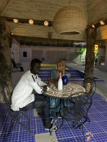 a man sitting at a table with a doll at it at Cuckoo's Nest in Tanji