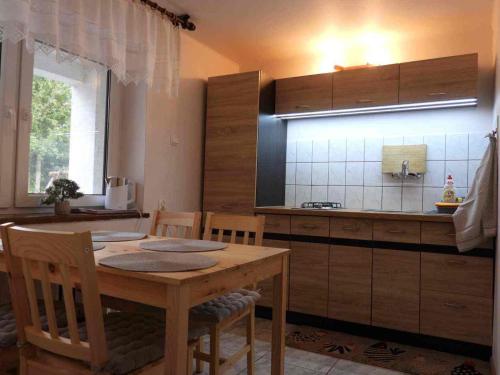 a kitchen with a wooden table and a kitchen counter at DOMKI , Pokoje gościnne Ustronie in Zwierzyniec