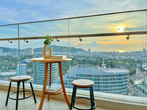 una mesa y dos taburetes frente a una ventana en Căn hộ The Sóng Vũng Tàu, en Vung Tau