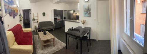 a living room with a couch and a desk in a room at [ Hébergement partagé à proximité de la place du marché à Bastia ] in Bastia