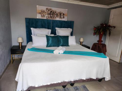 Un dormitorio con una cama grande con dos toallas encima. en Gift from G guesthouse, en Witbank