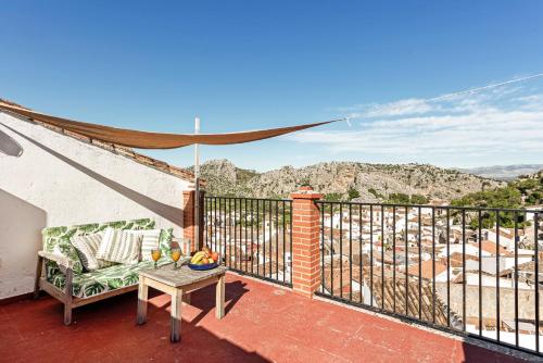 een balkon met een bank en een tafel bij Casa Rural con vistas espectaculares in Montejaque