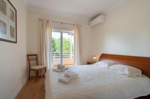 ein Schlafzimmer mit einem Bett, auf dem zwei Handtücher liegen in der Unterkunft VILAMOURA Two Bedroom Near Praia Falésia in Quarteira