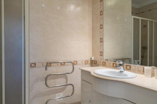 ein Badezimmer mit Waschbecken und Spiegel in der Unterkunft VILAMOURA Two Bedroom Near Praia Falésia in Quarteira