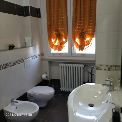 a bathroom with a white toilet and a sink at La Magnolia - Fano in Fano