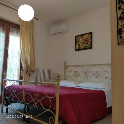 a bedroom with a bed with a red blanket at La Magnolia - Fano in Fano