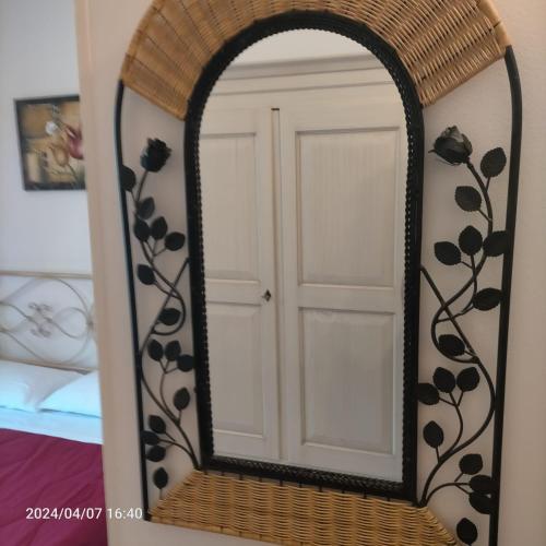 a mirror with a black flower design on a wall at La Magnolia - Fano in Fano
