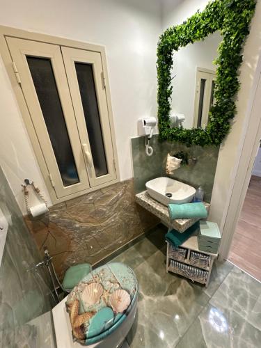 a bathroom with a sink and a mirror at La Casa Delle Conchiglie in Catania