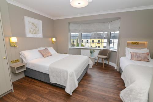 ゴールウェイにあるUrban Nest Townhouseのベッド2台と窓が備わるホテルルームです。