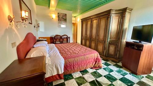 a bedroom with a bed and a flat screen tv at Hotel Raffaello - Self Check-in Free in Urbino