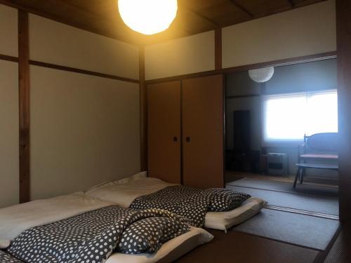 a bed in a room with a light on the ceiling at みちくさ能勢 in Noma-naka