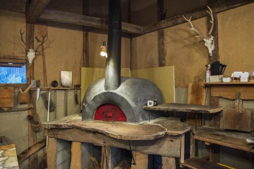 a stone oven with a red door in a room at みちくさ能勢 in Noma-naka