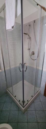 y baño con cabina de ducha con puertas de cristal. en Palermo Central Apartments, en Palermo
