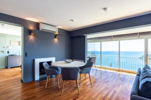 un salon avec une table et des chaises dans l'établissement 73 CORNE D OR - Toit Terrasse - Vue Mer Panoramique - Jaccuzzi, à Villefranche-sur-Mer