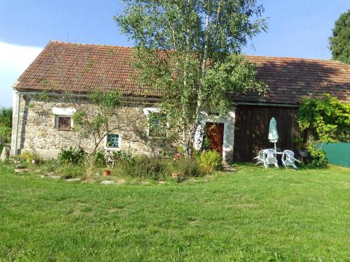 a stone house with two cows in front of it at ROSE COTTAGE (sleeps 4) in Chlum u Třeboně