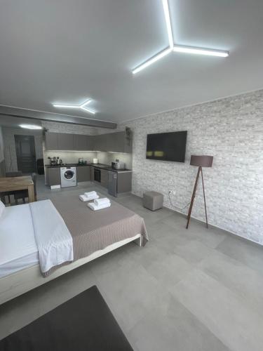 una camera con un grande letto e una cucina di AVR Airport Deluxe Suites 6 a Markopoulo