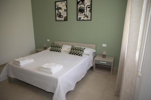 1 dormitorio con 1 cama blanca y 2 almohadas en Casa Raineri, en Paceco