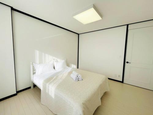 Un dormitorio con una cama blanca con una toalla. en Highvill Park 2-Room Apartments, en Astana