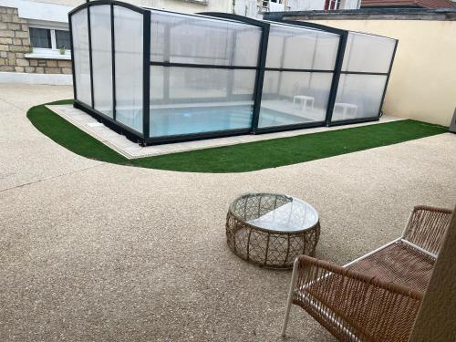 une maison en verre avec un banc et une table en verre dans l'établissement La Dream Night, à Pontault-Combault