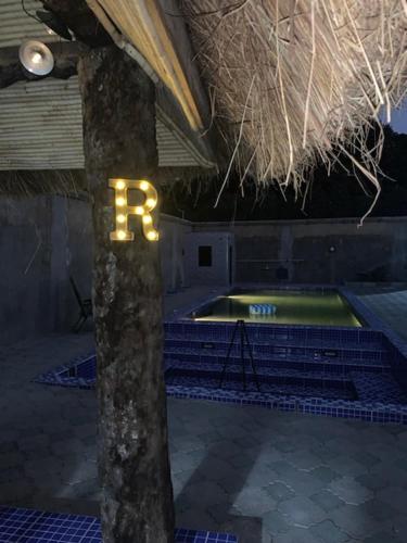 a tennis court with a b sign on a tree at Cuckoo's Nest in Tanji