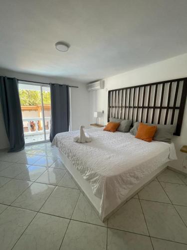 een slaapkamer met een groot wit bed met oranje kussens bij HUMMINGBIRD CABARETE in Cabarete