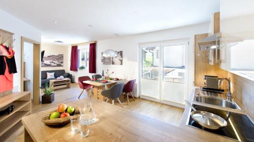 a kitchen with a table with a bowl of fruit on it at Apartment Dorfjuwel in Oberau