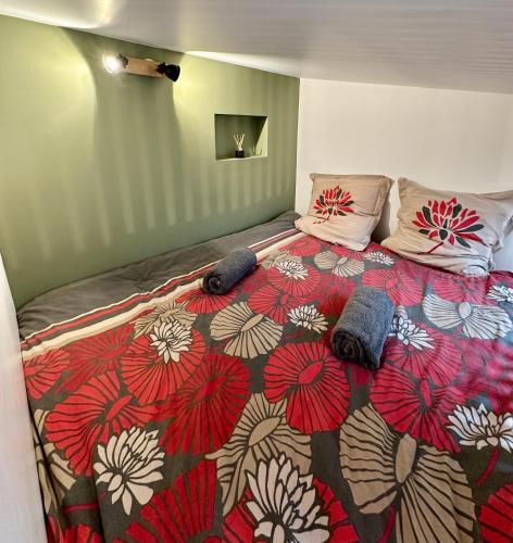 a bedroom with a bed with a red and white blanket at Studio "Cocon Suspendu" 4 pers-Terrasse-Clim-Barbecue-15km des plages in Montpellier