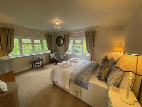a bedroom with a large bed and windows at Huntleys Lodge in Ticehurst