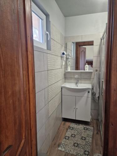 a bathroom with a sink and a mirror at Cabanute Maya Transalpina in Săsciori