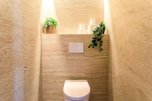 a bathroom with a toilet and plants on a wall at La Picolla Bellezza in Mandelieu-la-Napoule
