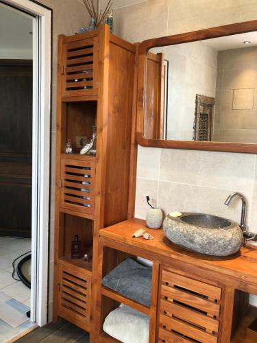 une salle de bain avec un lavabo et un miroir dans l'établissement Bienvenu chez Nathalie, à Châtillon