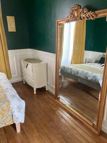 um espelho num quarto com uma cama e uma cómoda em Cosy appartement in Paris em Paris