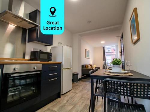 uma cozinha com uma mesa e um frigorífico em Cosy and Homey 1br flat in Sunderland Centre - Flat 2 em Sunderland
