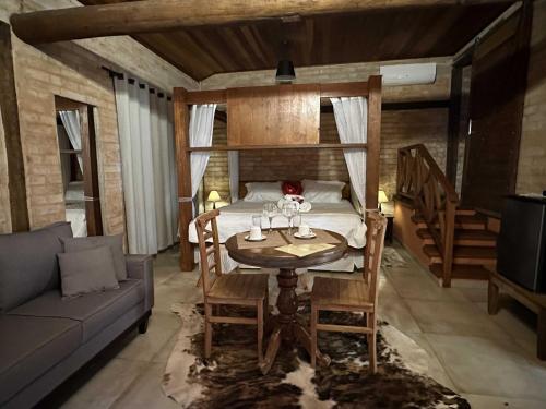 a room with a table and a bed and a couch at Estalagem Wiesbaden in Monte Verde