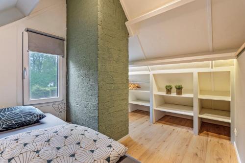 a bedroom with a green accent wall and a bed at Luxe Bos bungalow met Airco in Posterholt