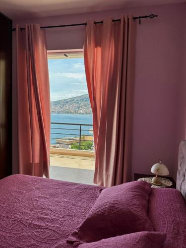 a bedroom with a window with a view of the ocean at Esmeralda Apartaments in Sarandë